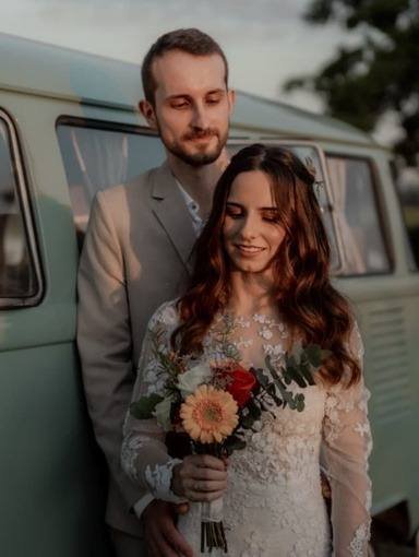 Noivos encostados em uma Kombi antiga verde-água